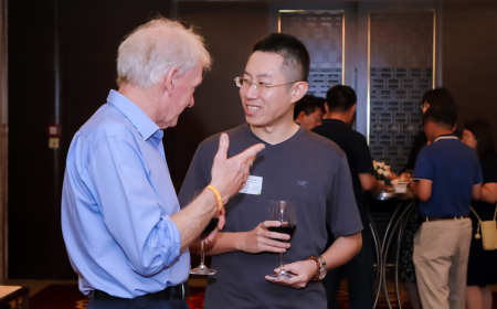 Two alumni engaged in conversation, networking at a global UCD Alumni event.